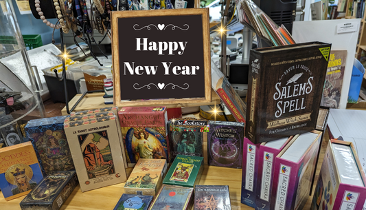 A sign saying 'Happy New Year' among boxes of tarot cards and crystal kits