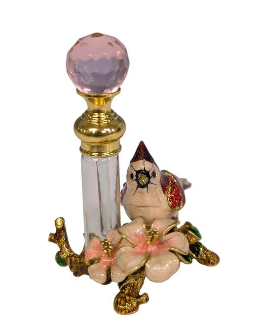 Decorative object with a bird figure, pink gem, and floral design on a white background