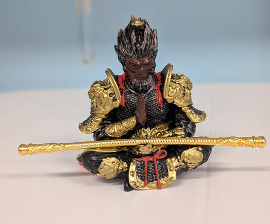 Decorative figurine of a warrior holding a sword on a white surface with a light blue background